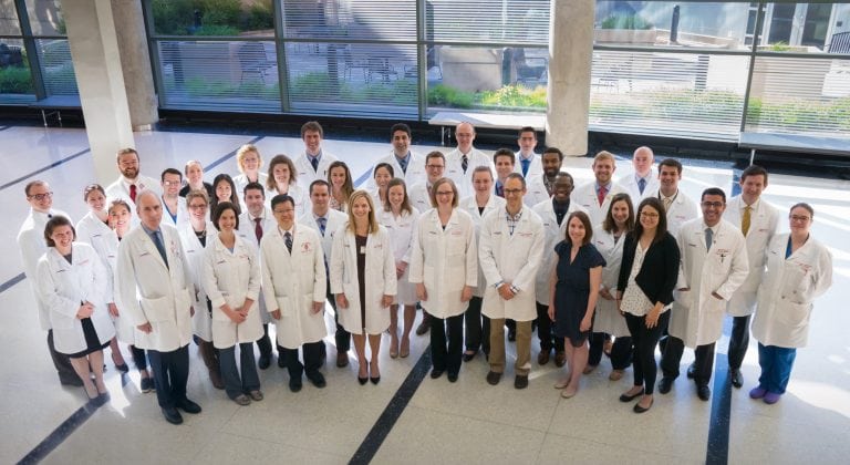 Group of residents standing in white coats in hallway