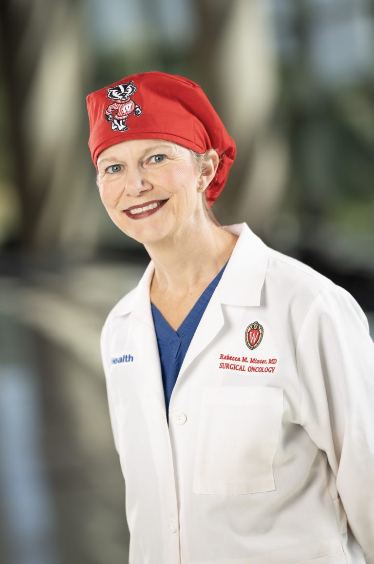 Photo of Dr. Rebecca Minter in white coat and red Bucky Badger scrub cap